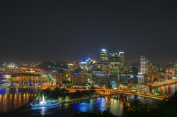 Three rivers meet in downtown Pittsburgh at night.