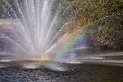 Rainbow in the fountain. Komsomolskiy pond with Fountains in sunny day, Lipetsk, Russia