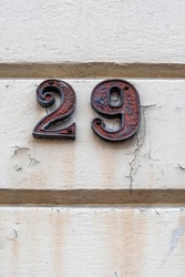 Number twenty nine on white painted plaster wall