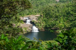 Gorgeous waterfall with two falls in the middle of  Iriomote island forest. Amazing natural pool, tropical vegetation around. Iriomote Island.