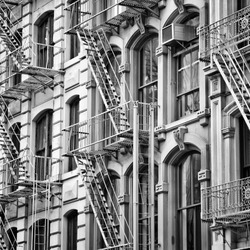 Old New York City architecture. Fire escape stairs. Black and white style.