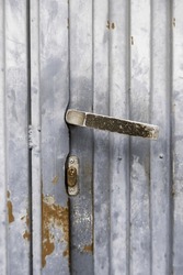 Detail of an old metal handle to open an abandoned door