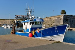 Fishing boat and the castle walls at Le Chateau d’Oleron, a  located on the island of Oleron in the Charente-Maritime department in southwestern France
