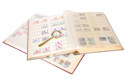 Stamp collection albums with magnifying glass on a white background