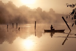 A misty morning by the lake. Small fishing boat at the lake.  Space for text.