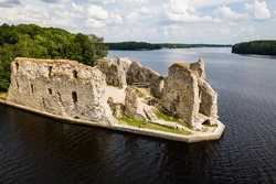 Aerial view of an old stone castle ruins in Koknese, Latvia. Located on a peninsula near the Daugava river and Perse river.