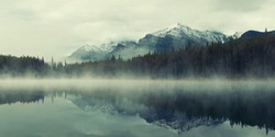 Lake Herbert panorama in a foggy morning with glaciers mountain and reflection in Banff National Park, Canada