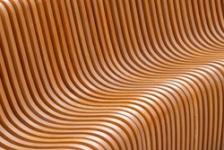 close-up full frame view of curved parametric plywood public bench at daylight