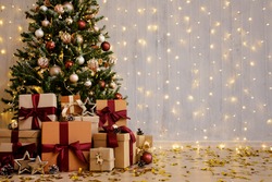 Beautiful decorated christmas tree and gift boxes with copy space over grey wall with lights