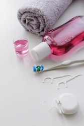 Mouthwash and other oral hygiene products on white background