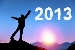 happy new year 2013. young man standing on the top of mountain watching the sunrise and cloud 2013