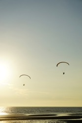 Silhouette of para gliding at sunset sky with sea background