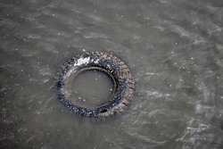 Abandoned tyre wheel at sea, Junk in nature problems 