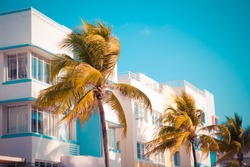 Vintage tone image of palm trees and typical retro art deco style buildings seen from South Beach Miami Florida 