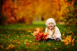 happy little girl have fun playing with fallen golden leaves