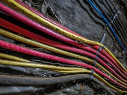 Power cables bundle in old salt mine attached to the underground corridor wall