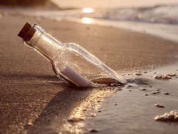 Message in the bottle washed ashore against the Sun setting down