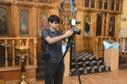 videographer working with camera and light at church