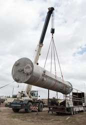Industrial zone. Unloading of processing equipment by means of the crane