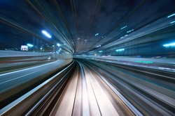 Motion blur of a city and tunnel from inside a moving monorail in Tokyo.
