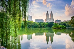 New York City, USA at the Central Park Lake and Upper West Side skyline.