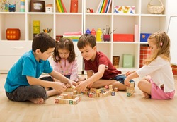 Children playing with blocks on the floor - focus on the boy's face
