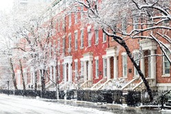Snowy winter street scene with historic buildings along Washington Square Park in Manhattan, New York City NYC