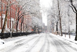 Snowy streets and sidewalks along Washington Square Park are empty during a winter blizzard in New York City