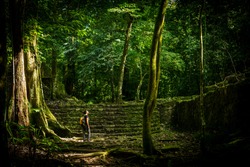 Adventure travel in jungle ruins with woman traveller