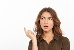 Portrait of a confused young woman looking away at copy space isolated over white background