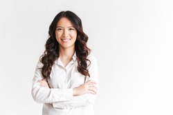 Portrait of gorgeous asian woman with long dark hair looking at camera with beautiful smile and arms crossed isolated over white background in studio