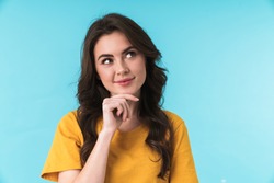 Image of a dreaming pleased young pretty woman posing isolated over blue wall background.