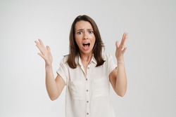 Young european woman gesturing and screaming at camera isolated over white background
