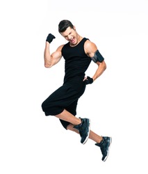 Full length portrait of a cheerful fitness man jumping isolated on a white background