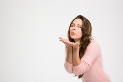 Beautiful woman blowing kiss isolated on a white background