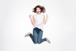 Full length portrait of a cheerful cute woman jumping isolated on a white background
