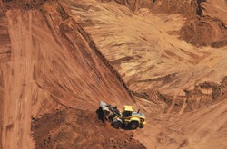 Heavy bulldozer loading red sand, an aerial view