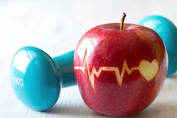Heartbeat line on red apple and dumbbell, healthy heart diet and sport concept