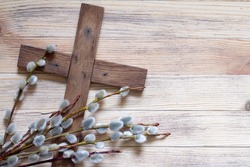 Easter cross with catkins on wooden background, palm sunday religious concept abstract