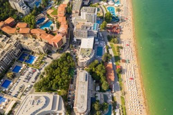 Aerial image a drone resort Golden Sands on Black Sea coast in Bulgaria. Many hotels and beaches with tourists, sunbeds and umbrellas. Sea travel destination. Travel and vacation concept