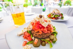 Dakos, Cretan salad with fresh vegetables, feta cheese and olives, Greece traditional cuisine.