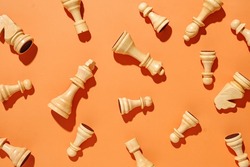 White chess pieces pattern on an orange background. Minimal concept of conflict and victory in sport life or business.