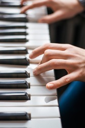 Close up of young girls hands, playing the keys