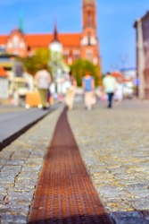 Pavers in central square of Kosciusko Market. On background Cathedral Basilica of Assumption of Blessed Virgin Mary in Bialystok, Poland. Selective focus on the pavement, blurred abstract background