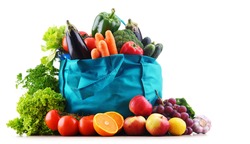 Shopping bag with vegetables and fruits on white background