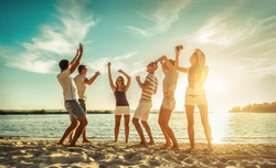 Happiness Friends funny dance on the beach under sunset sunlight in summer sunny day.
