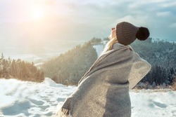 Happy woman enjoying sunset stay on mountain top of mountain and looking on beautiful winter snowy view. Christmas holiday. Snow day fun. 