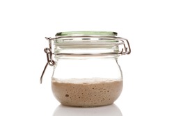 Home made starter yeast growing in a glass jar isolated on white background.