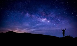 Silhouette of a happy photographer adventure trekking on  mountain with real fantasy stars and milky way in the night sky. Conceptual of amazing nature with great dream journey and voyage scene. 