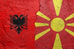 Albania and North Macedonia flags  - Cracked concrete wall painted with a Albanian flag on the left and a North Macedonian flag on the right